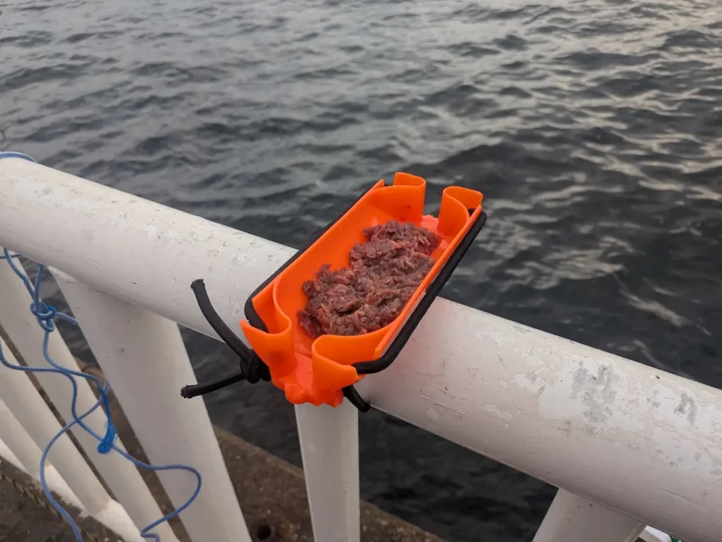 ダイソー「釣り用エサトレー」を付属の紐で手すりに取り付けた様子